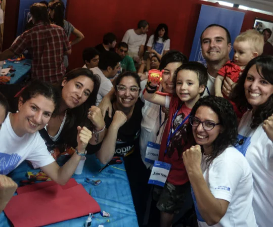 Volunteers and families from the Atomic Lab community smile together